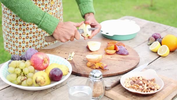Жінка ріже фрукти на відкритому повітрі — стокове відео