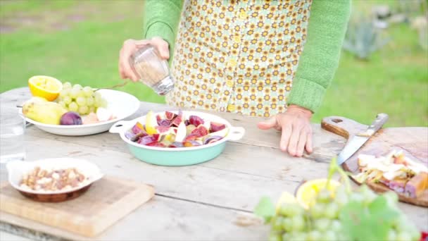 Vrouw toevoeging van kruiderijen aan versneden fruit — Stockvideo