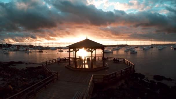 Waterfront pavilion overlooking harbor at sunset — Stock Video