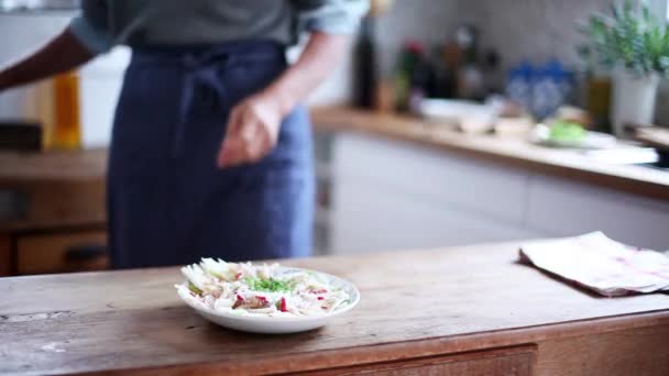 Жінка шліфує перець над салатом — стокове відео