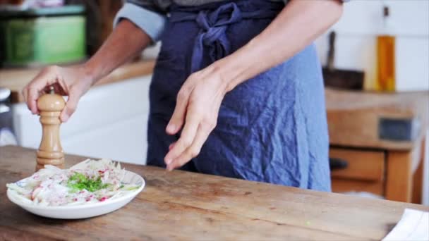 Frau zerkleinert Pfeffer über Salat — Stockvideo