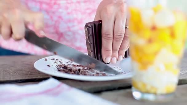 Rallar chocolate para agregar virutas a la ensalada de frutas — Vídeo de stock