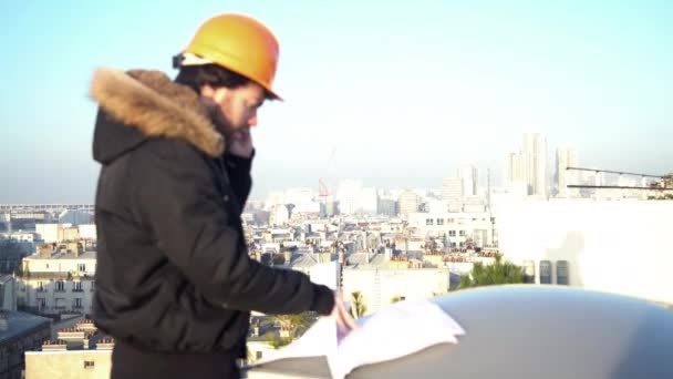 Bauleiter schaut sich Baupläne an — Stockvideo