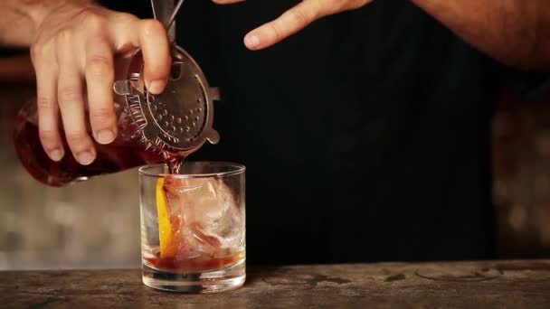 Bartender pouring cocktail into glass — Stock Video