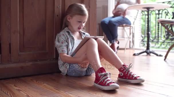 Маленькая девочка сидит на полу — стоковое видео