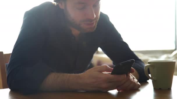 Чоловік дивиться на смартфон і розмовляє — стокове відео