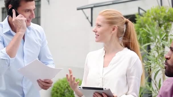 Colegas discutiendo el trabajo al aire libre — Vídeo de stock