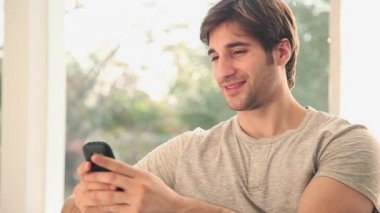 Metin mesajı gönderme ve cep telefonuyla konuşan adam 