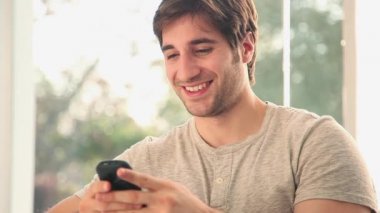 Metin mesajı gönderme ve cep telefonuyla konuşan adam 