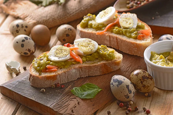 Sliced bread with pea cream and quail eggs — Stock Photo, Image