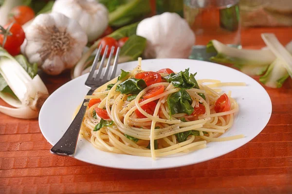Спагетти с мангольдом и помидорами — стоковое фото