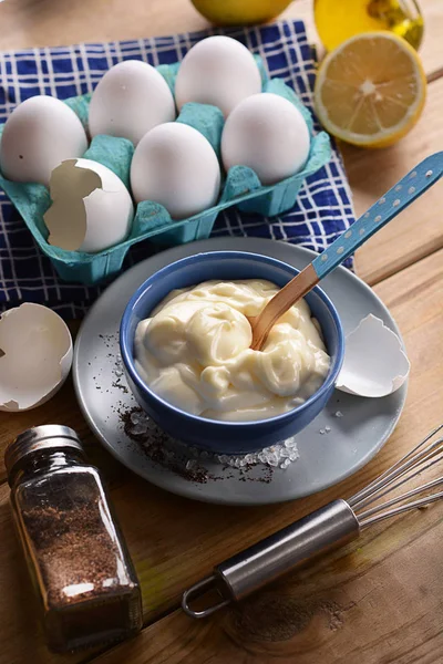 Mayonnaise in blue bowl with ingredients around — Stock Photo, Image