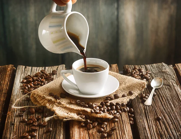 Despeje o café quente em pequena xícara branca — Fotografia de Stock