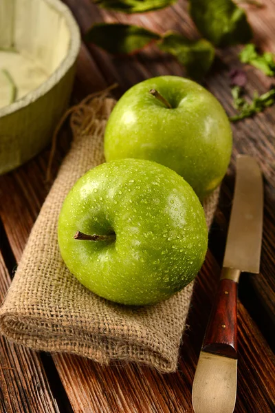 Zwei grüne Äpfel auf Jute-Serviette — Stockfoto