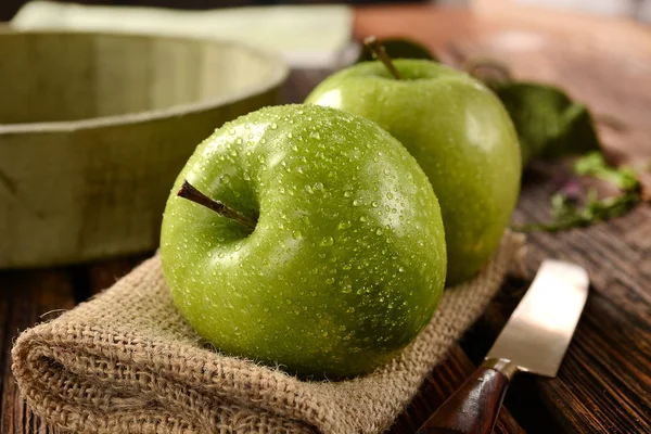 Два зеленых яблока на джутовой салфетке — стоковое фото