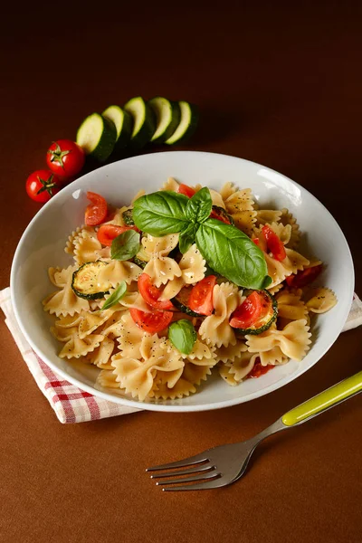 Fjäril pasta med tomat cherry och zucchini — Stockfoto