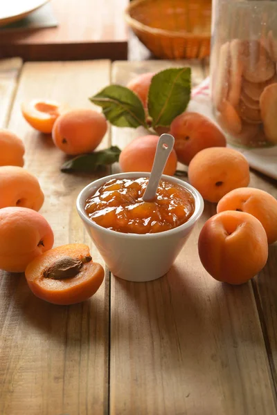 Apricot jam in white bowl with fruit around — Stock Photo, Image