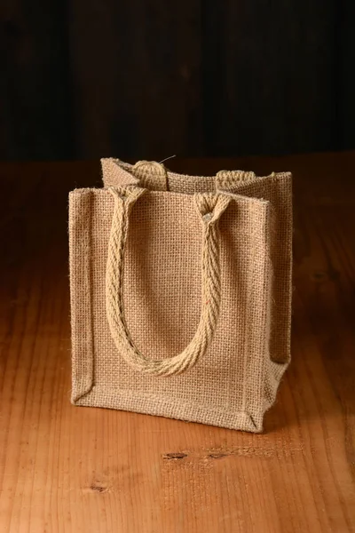 Pequeno saco de juta na mesa de madeira — Fotografia de Stock