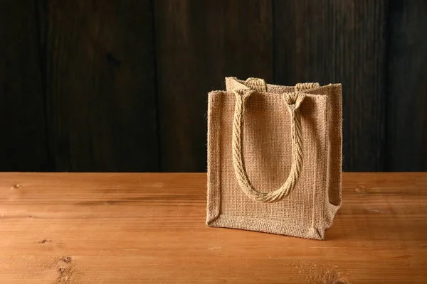 Small jute bag on wooden table