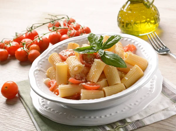 Těstoviny s rajčaty v kusech s lístkem bazalky — Stock fotografie