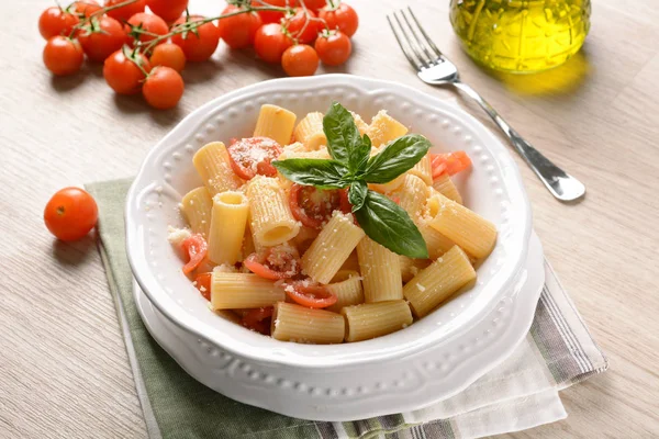 Pasta with tomato in pieces with basil leaf — Stock Photo, Image