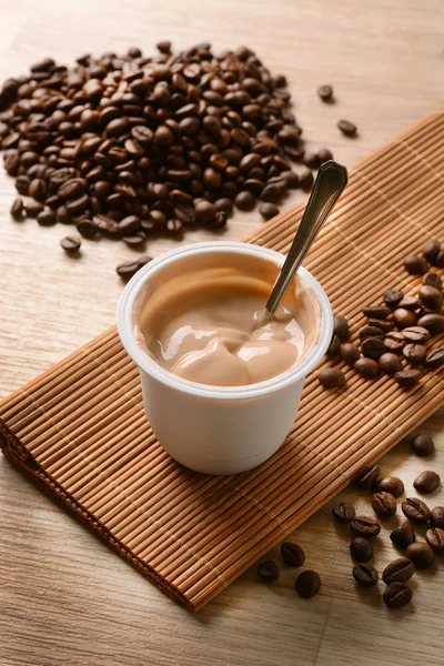 Kaffe-smaksatt yoghurt med kaffebönor runt — Stockfoto