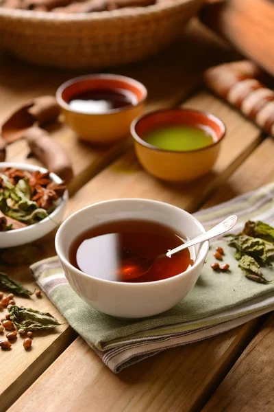 Relajante té de hierbas en el tazón con ingredientes alrededor — Foto de Stock