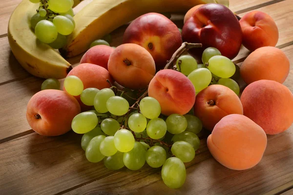 Różne owoce na drewnianym stole — Zdjęcie stockowe