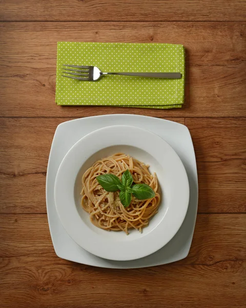 Celozrnné špagety s parmazánem sýrem a čerstvou bazalkou listy — Stock fotografie