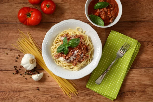Spaghetti with meat sauce with ingredients around — Stock Photo, Image
