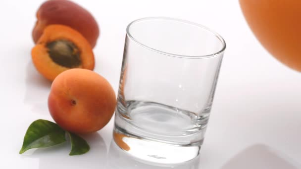 Залить абрикосовый сок - белый фон - замедленная съемка — стоковое видео