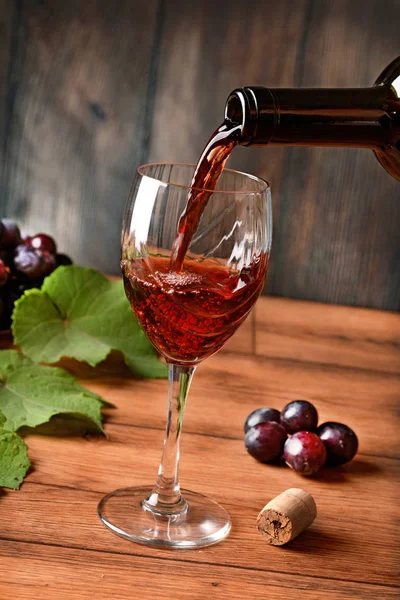 Kırmızı şarap cam - ahşap arka plan - closeup dökün — Stok fotoğraf