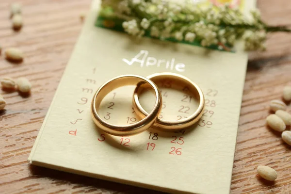 Золотые свадебные кольца в календаре — стоковое фото