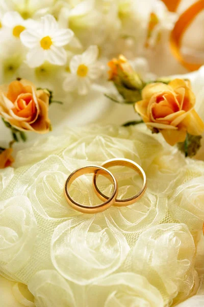 Zlaté snubní prsteny s květinami a okolí Stock Snímky