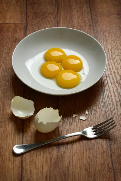 Egg yolk with fork on wooden table — Stock Photo, Image