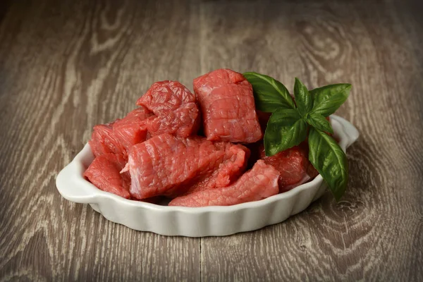 Pedaços de carne na mesa com outros ingredientes — Fotografia de Stock