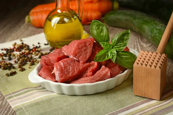 Pedaços de carne na mesa com outros ingredientes — Fotografia de Stock