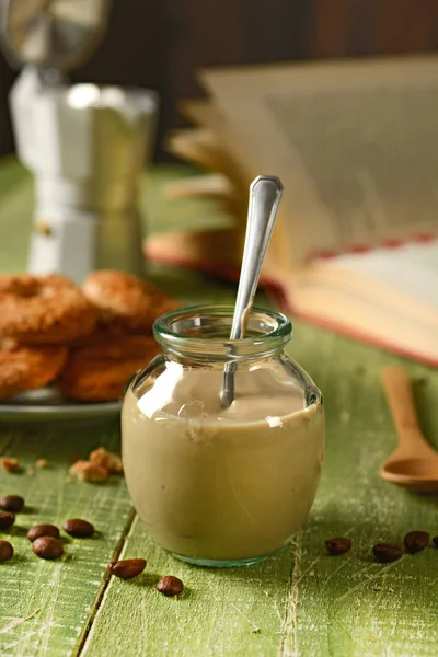Yogur de café en frasco de vidrio sobre mesa de madera verde — Foto de Stock