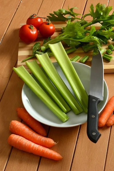 Apio, zanahorias y tomate con cuchillo al lado —  Fotos de Stock