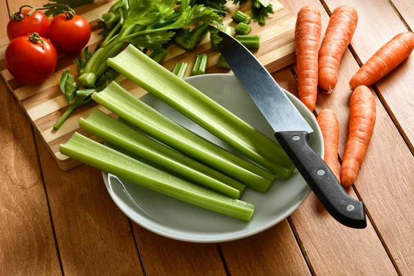 Aipo, cenoura e tomate com faca ao lado Imagem De Stock
