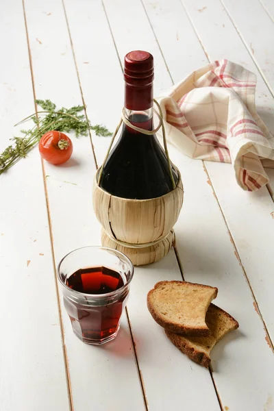 Glass of red wine with the flask next to it — Stock Photo, Image