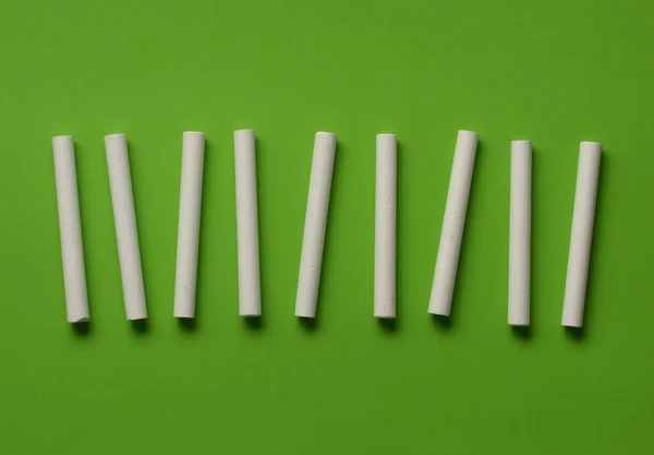 Pile of white chalks on a green background — Stock Photo, Image
