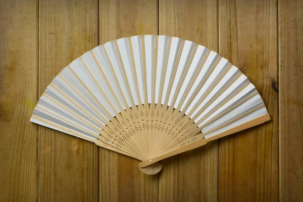 Ventilatore pieghevole isolato su fondo di legno — Foto Stock