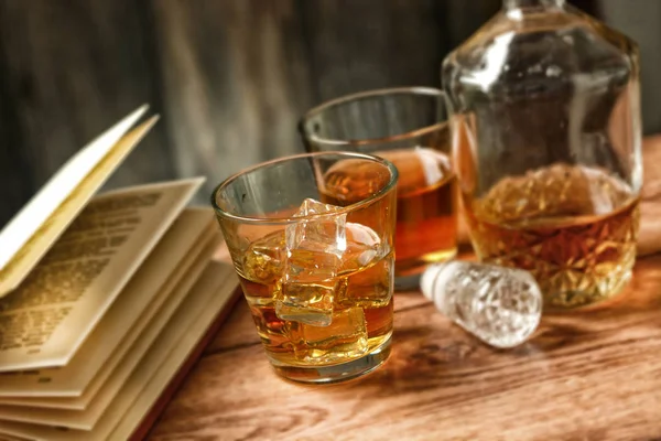 Glasses of whiskey with ice and open book - selective focus — Stock Photo, Image