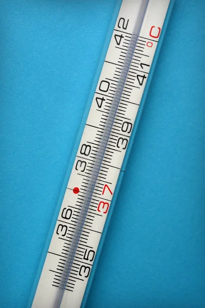 Thermometer zur Messung der Körpertemperatur auf blauem Hintergrund — Stockfoto