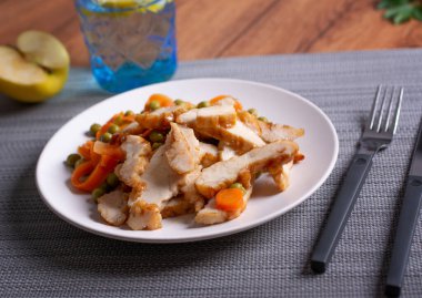 Bezelye ve havuçlu kızarmış tavuk eti. Yakın plan.