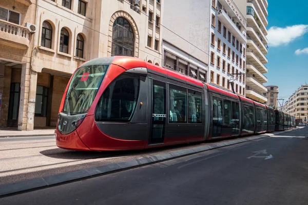 Demiryolları üzerinde eski binalar arasında geçen bir tramvay