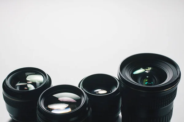 Vista de primer plano de un grupo de lentes de cámara sobre una superficie blanca —  Fotos de Stock