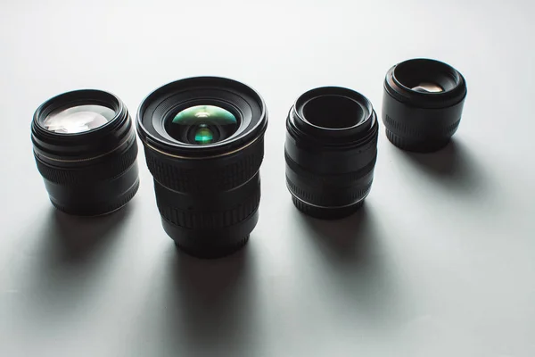 Vista de primer plano de un grupo de lentes de cámara sobre una superficie blanca —  Fotos de Stock