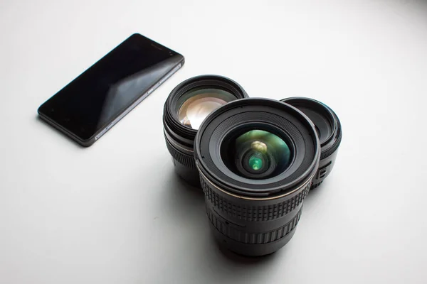 Primo piano di gruppo di obiettivi di macchina fotografica e un telefonino su un bianco — Foto Stock